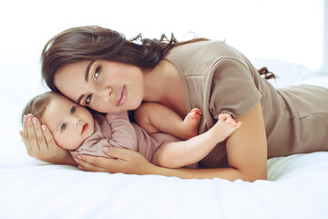 Obraz na płótnie Canvas A young mother is holding her newborn baby. Mother of a nursing baby. Mother breastfeeding her baby. The family is at home. Portrait of a happy mother and child. High quality photo.