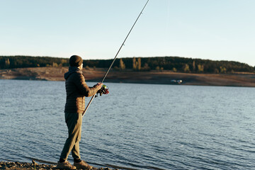 Fisherman with rod fishing on the lake