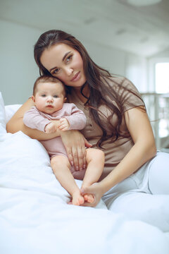 A young mother is holding her newborn baby. Mother of a nursing baby. Mother breastfeeding her baby. The family is at home. Portrait of a happy mother and child. High quality photo.