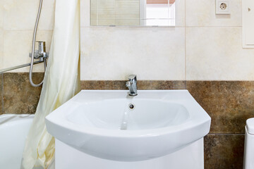 White ceramic sink near bathtub in bathroom