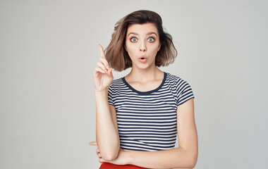 Obraz premium pretty model woman in striped t-shirt gesturing with hands on gray background Copy Space