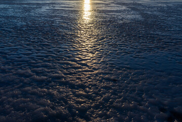 Sun reflection on the ice . Winter Sunset in the Village