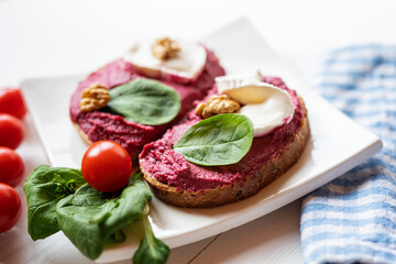 red beetroot brie goat cheese walnut dip sandwich bread spread with salad on white porcelain plate 