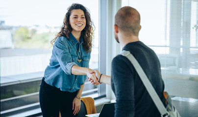 Businesswoman shaking hands with a job applicant - obrazy, fototapety, plakaty