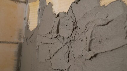 The builders are using triangular steel to smooth the plaster evenly in the walls of the house. concepts of the construction industry with skilled workers. The craftsman evens the putty on the wall.