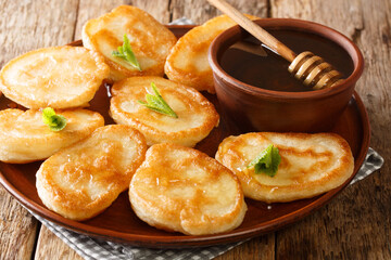 Authentic Tiganites Greek pancakes with honey close-up in a plate on the table. horizontal