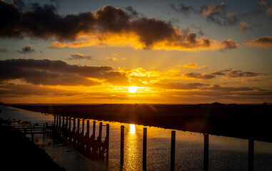 Fototapeta premium Friedrichskoog Rugenort Blick auf den alten Hafen Fluss bis zur Nordsee Sonnenuntergang, Schleswig Holstein, Deutschland