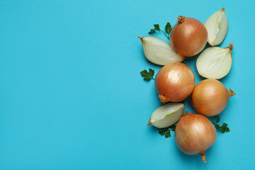 Obraz na płótnie Canvas Fresh ripe onion and parsley on blue background