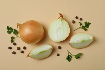 Onion, peppercorns and parsley on beige background