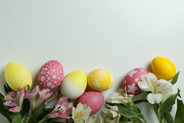 Color Easter eggs and alstroemeria flowers on white background
