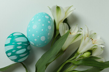 Color Easter eggs and alstroemeria flowers on white background