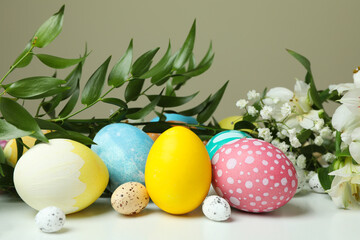 Easter eggs and beautiful flowers on white table