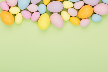 Stylish background with colorful easter eggs pastel colors isolated on green background. Flat lay, top view, mockup, overhead, template