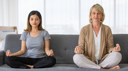 Fototapeta na wymiar Multiracial mother and daughter in law meditating at home