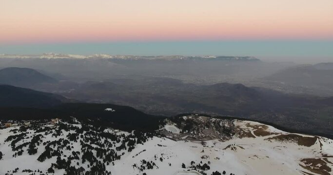 Alpine landscape at Chamrousse France during cold morning sunrise with pastel colors, Aerial pan left reveal shot