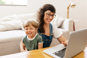 Woman working on laptop with her son