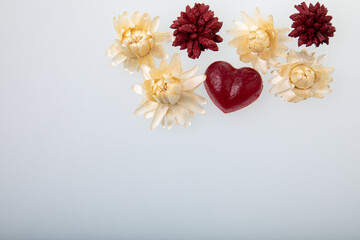 Sweet jelly candy heart shape and dried flowers on white background with free text space