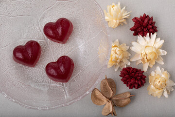 Fototapeta na wymiar Sweet jelly candies heart shape and dried flowers on white background