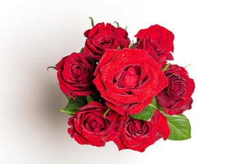 A bouquet of red roses, on a light background. Close-up of dew drops on the petals. In the concept of congratulations on a holiday, anniversary, birthday there is a place for text.