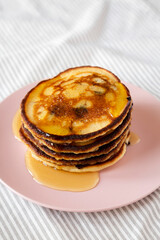 Homemade Peanut Butter Chocolate Pancakes on a pink plate, side view.