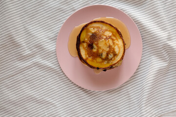 Homemade Peanut Butter Chocolate Pancakes on a pink plate, top view. Flat lay, overhead, from above.