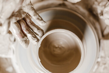 Female hands make dishes from clay