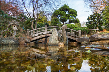 Fototapeta na wymiar Pool and bridge detail in the Japanese Garden at Hillwood Estate, in Washington, D.C.