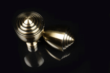 metal curly items on a black background with reflection