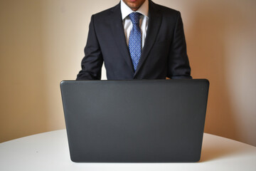 businessman wearing a suit and working with a portatail from home