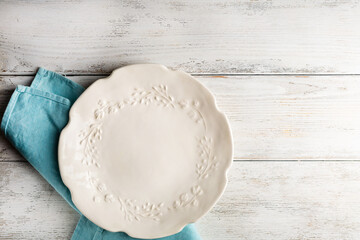 Overhead view of vintage white plate on wooden table