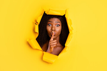 Photo of secretive gossip excited lady finger close lips look camera through ripped yellow color background