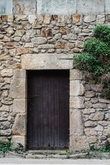 Old wooden door in masonry stone wall