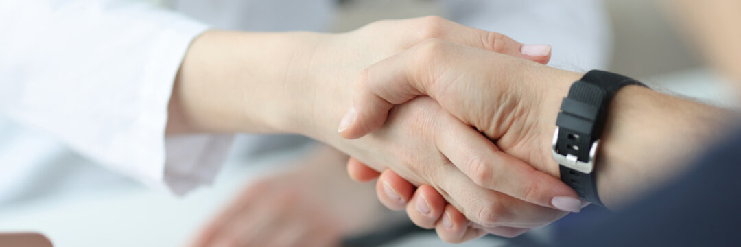 Closeup of doctor and patient handshake in clinic