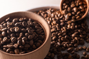 Dark Coffee Beans in a wooden Cup. Symbolic image. Rustic wooden background. Close up. Copy space.