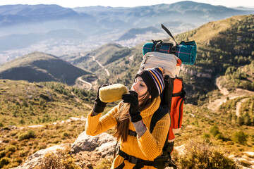 Young mountaineer girl drinks water from her canteen