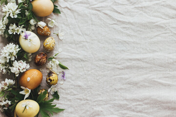 Easter rustic flat lay, eggs with spring flowers on linen cloth, space for text. Aesthetic holiday