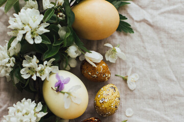 Easter rustic flat lay with eggs and spring flowers on linen background. Aesthetic eco holiday