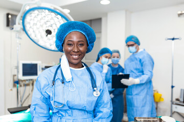 Close-up of a African American surgeon woman looking at camera with colleagues performing in...