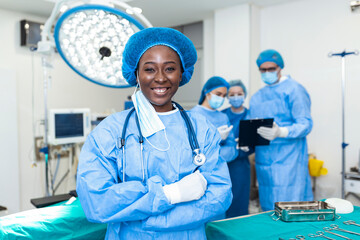 Portrait of surgeon standing in operating room, ready to work on a patient. African American Female...