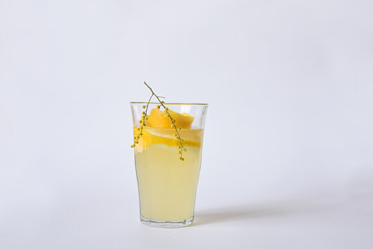 Lemon Drink In A Glass Of Mimosa Willows On A White Background.