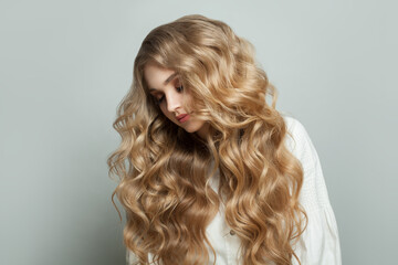 Healthy blonde woman with wavy hair on white background