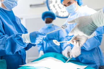 Low Angle Shot in the Operating Room, Assistant Hands out Instruments to Surgeons During Operation....
