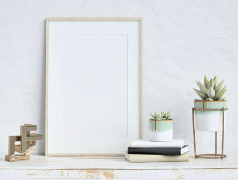 Mock up poster frame on white plaster wall with echeveria plants in pots, books and geometric object on old wooden table; portrait orientation; stylish frame mock up; 3d rendering, 3d illustration