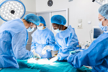 Surgical team performing surgery in modern operation theater,Team of doctors concentrating on a...