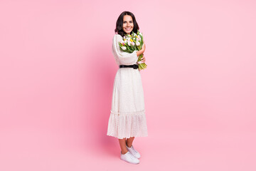 Full body photo of charming attractive young woman hold hands spring flowers isolated on pastel pink color background