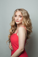 Pretty woman blonde fashion model in red dress on white background