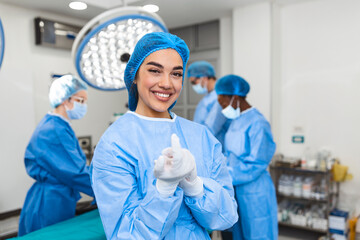 Portrait of beautiful female doctor surgeon putting on medical gloves standing in operation room. Surgeon at modern operating room