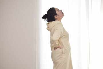 A young pregnant woman is suffering from back pain. My back tends to hurt during pregnancy.