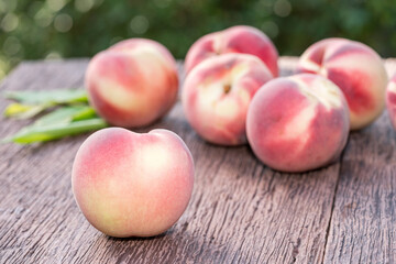Fresh Peach fruits on wooden table in blur background, Peach  on wooden table in garden.