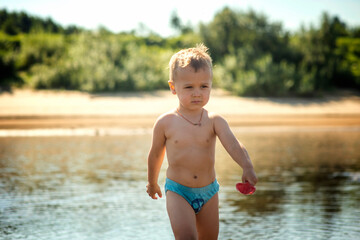 small child boy 3 years old playing on the beach, selective focus